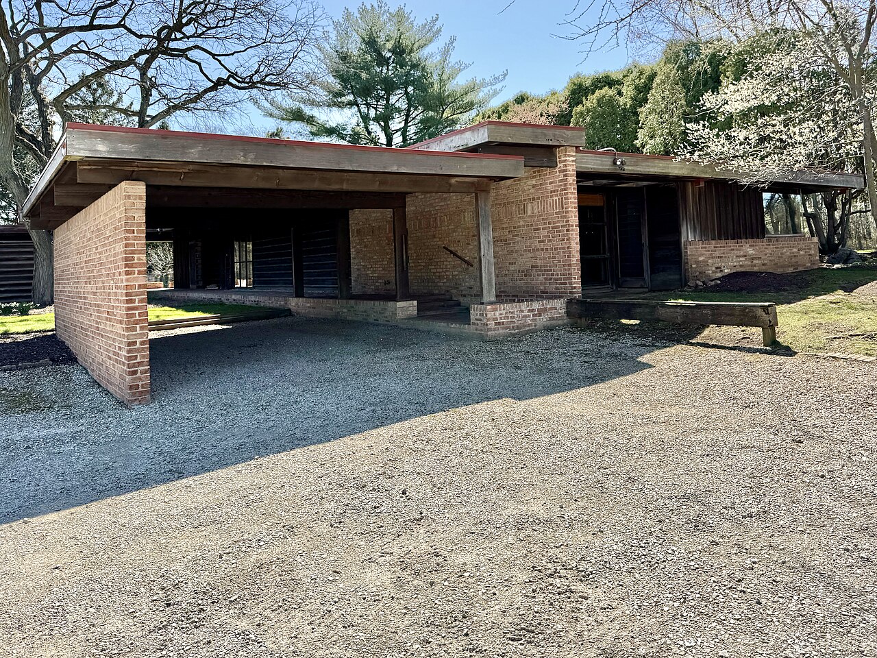 Offener Carport mit Stützen vor einem Haus